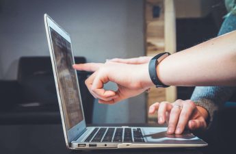 Un computer portatile e due persone che guardano qualcosa
