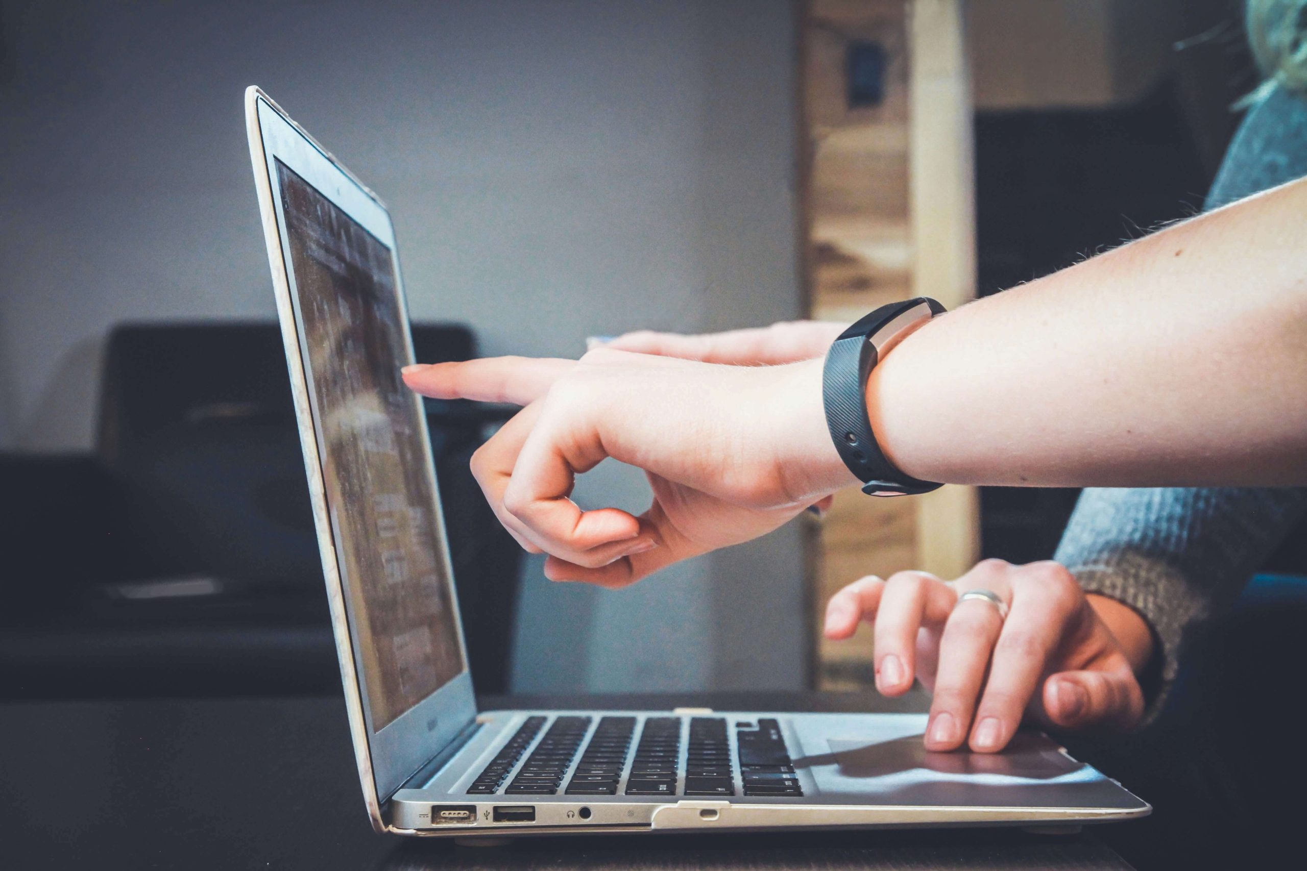 Un computer portatile e due persone che guardano qualcosa